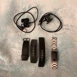 Fitbit Charge 3 with two black bands, a silver metal band, and 2 charging cables